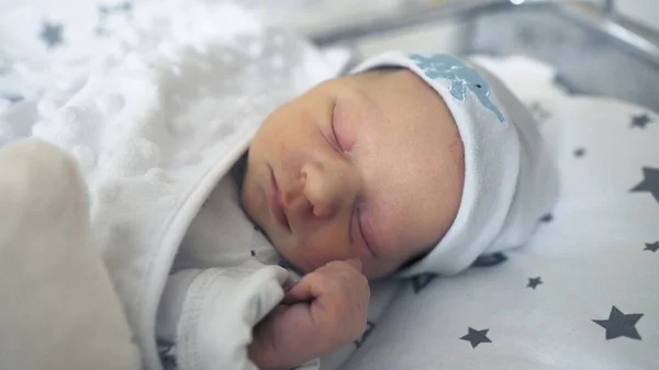 Adorável bebê recém-nascido dormindo pacificamente em seu berço no quarto do hospital — Fotografia de Stock