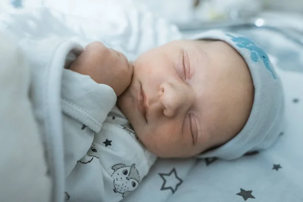 Liebenswertes Neugeborenes schläft friedlich in seinem Kinderbett im Krankenhauszimmer — Stockfoto