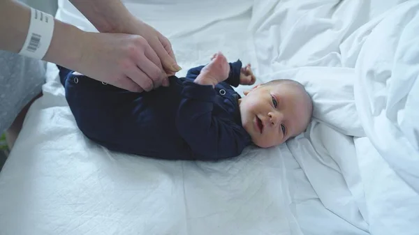 Mãe vestir seu bebê recém-nascido, de perto — Fotografia de Stock