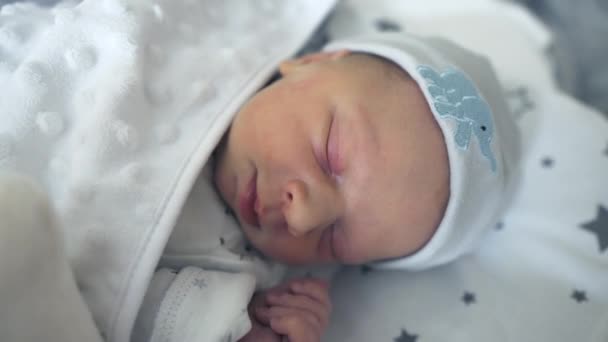 病院の部屋で彼のベビーベッドで快適な新生児の睡眠と笑顔 . — ストック動画