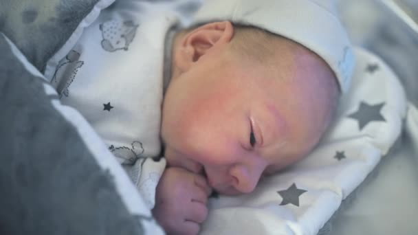 可爱的新生婴儿正试图把头抬起来放在婴儿床里 — 图库视频影像