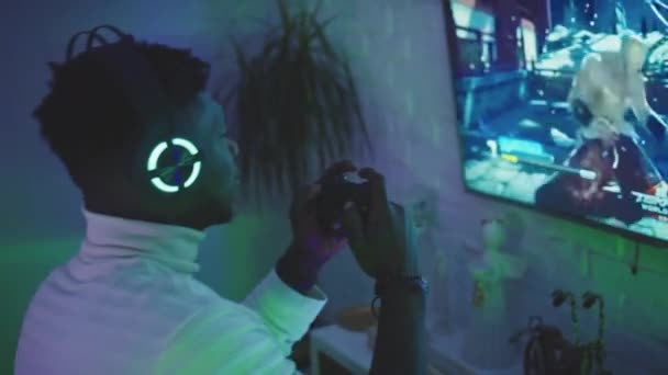 Entretenimento doméstico. Homem negro jogando jogos de vídeo usando controlador joystic — Vídeo de Stock