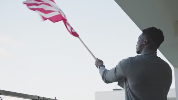 Jonge aantrekkelijke zwarte man zwaaien Amerikaanse vlag — Stockvideo