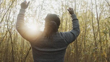 Doğada elini uzatan Afrikalı genç bir adam. Dua ya da kutlama. Kazanan