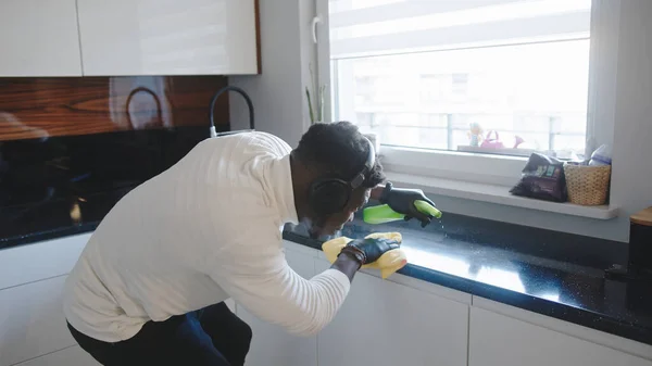 Homem negro a limpar cozinha. Germaphobe excessivamente limpando a superfície reflexiva — Fotografia de Stock