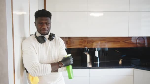 Joven negro satisfecho admirando limpiezas de la cocina después del trabajo — Vídeos de Stock