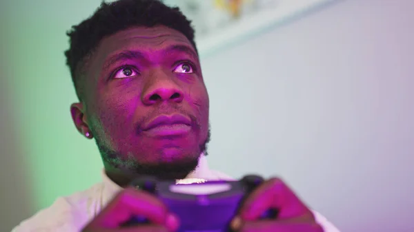 Homem negro jogando jogo usando console controle joystick. Entretenimento durante o encerramento. Jogo perdido — Fotografia de Stock