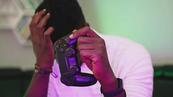 Hombre negro jugando a juegos usando consola controlando joystick. Entretenimiento durante el encierro. Perdido juego — Foto de Stock