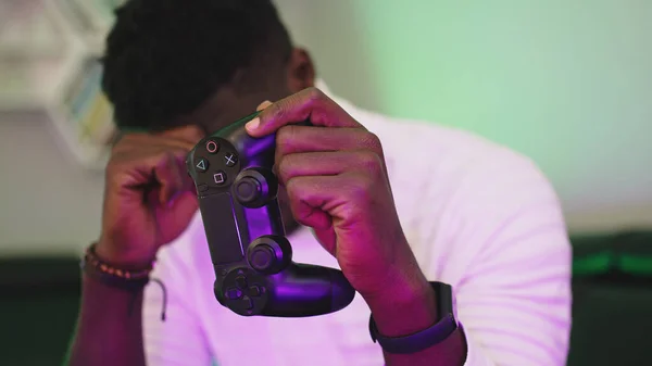 Hombre negro jugando a juegos usando consola controlando joystick. Entretenimiento durante el encierro. Perdido juego — Foto de Stock