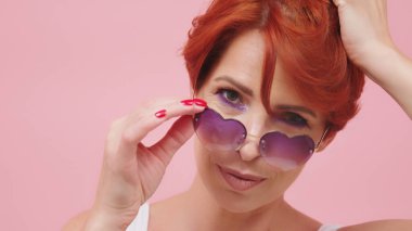 Kalp şeklinde gözlüklü, orta yaşlı, güzel kızıl saçlı kadının portresi. Güzel atış.