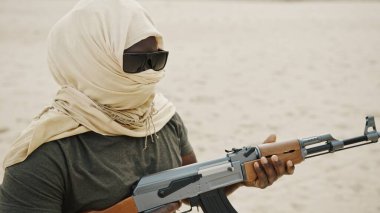 Terörizm kavramı. Asi asker AK-47 makineli tüfekle hedefleri hedef alıyor. Kapat..