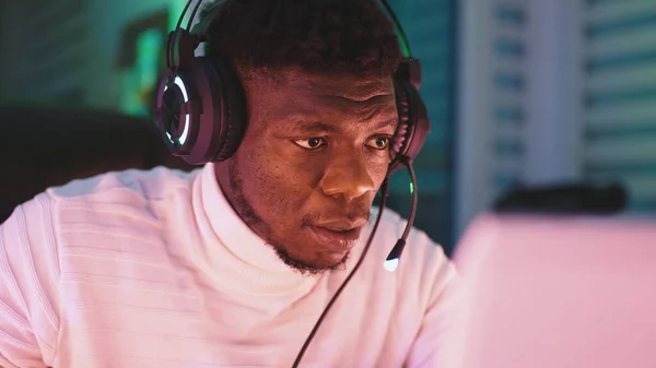 Vrolijke jonge zwarte man met verlichte headset met laptop. Thuiskantoor en afstandsbediening concept. Portret van de handelaar — Stockfoto