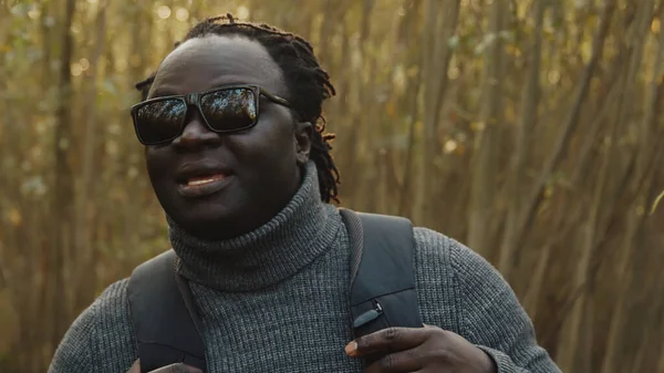 Jonge Afro-Amerikaanse zwarte man reiziger met rugzak wandelen door het bos — Stockfoto