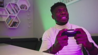 Zenci adam kumanda konsolunu kullanarak oyun oynuyor. Kilitleme sırasında eğlence. Kaybetme oyunu