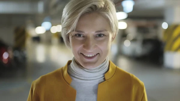 Portre, genç sarışın kadın yeraltı garajında gülümsüyor. — Stok fotoğraf
