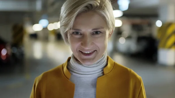 Porträt: Junge Business-Blondine lächelt in der Tiefgarage — Stockfoto