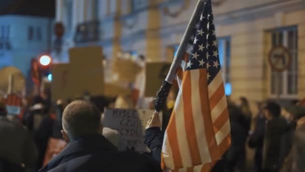 Varşova, Polonya 30.10.2020 Kürtaj ve insan hakları protestosu, kadın grevi. Kalabalıkta ABD bayrağı tutan adam — Stok video