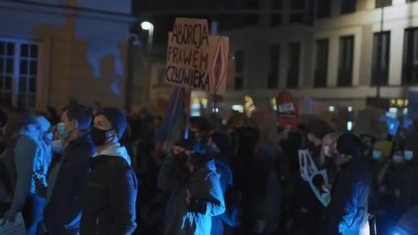 Varšava, Polsko 30.10.2020 - Protest proti potratům a lidským právům, stávka žen, demonstranti projíždějící kolem policejního auta osvětleného pohotovostním světlem — Stock video