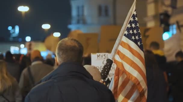 Warszawa, Polska 30.10.2020 - Protest przeciwko aborcji i prawom człowieka, strajk kobiet,. Mężczyzna trzyma flagę USA w tłumie — Wideo stockowe