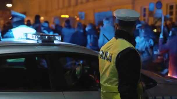 Warschau, Polen 30.10.2020 - Anti-abortus en mensenrechtenprotest, Vrouwenstaking, demonstranten in de buurt van politieauto verlicht door noodlicht — Stockvideo