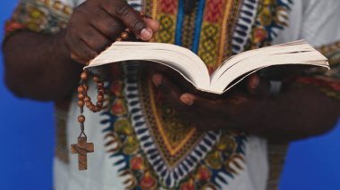 Geleneksel giysili, kutsal İncil okuyan tanınmamış Afrikalı siyahi adam. 
