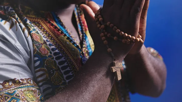 Unrecognizable African black man in traditional dress with rosary reading the Holy Bible — Stock Photo, Image
