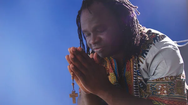 Geleneksel elbiseli Afrikalı siyahi adam tespihle dua ediyor. — Stok fotoğraf