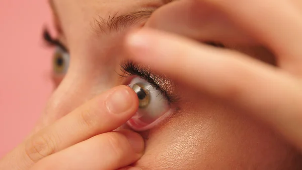 Close up, jovem caucasiana colocando lentes de contato sobre seus olhos verdes — Fotografia de Stock