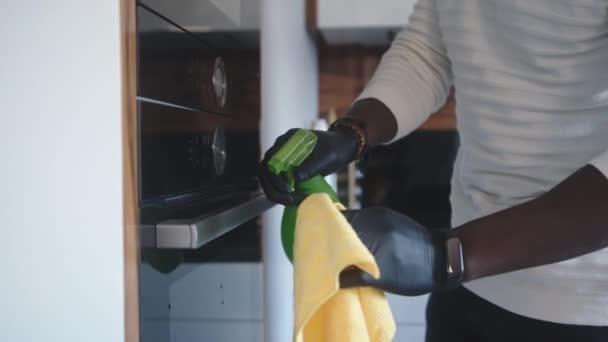 Gros plan, homme noir avec gants pulvérisation et nettoyage construit en owen — Video