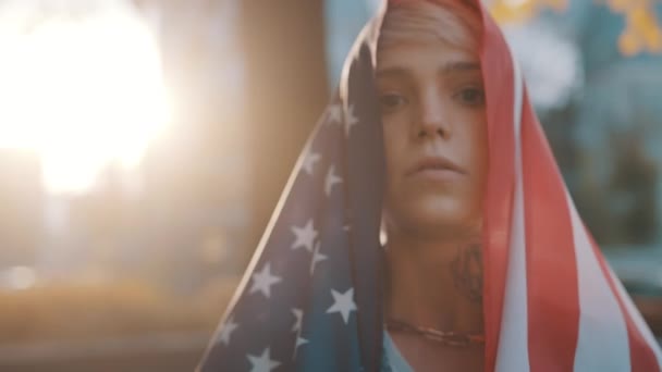 Портрет молодой блондинки с флагом США над головой в день выборов — стоковое видео