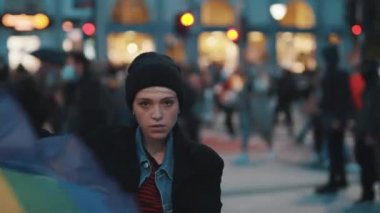 Protestodaki genç kadın gökkuşağı bayrağı sallıyor. covid-19 salgını sırasındaki gösteriler ve eşit haklar talebi