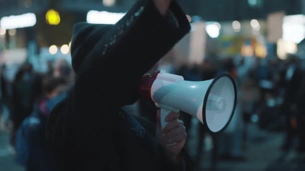 Молодая женщина в маске для лица выкрикивает лозунги на уличном протесте — стоковое видео