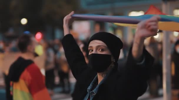 Mulher jovem detém grande arco-íris Lgbt bandeira e caminha em sinal de igualdade de direitos. Protesto de rua — Vídeo de Stock