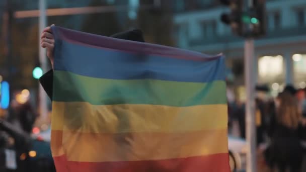 Ung kvinna med ansiktsmask rymmer stora regnbåge Lgbt flagga och går i tecken på lika rättigheter. Gatuprotest — Stockvideo