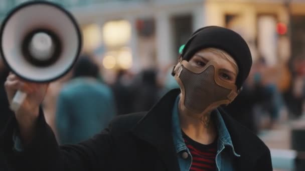 Женщина в маске и мегафоне поддерживает антирасистские протесты. — стоковое видео