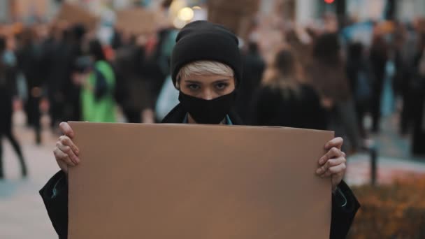 Protester och demonstrationer. upprorisk kvinna med ansiktsmask slående — Stockvideo