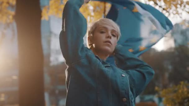 Jovem mulher caucasiana girando no parque com a bandeira da união europeia — Vídeo de Stock