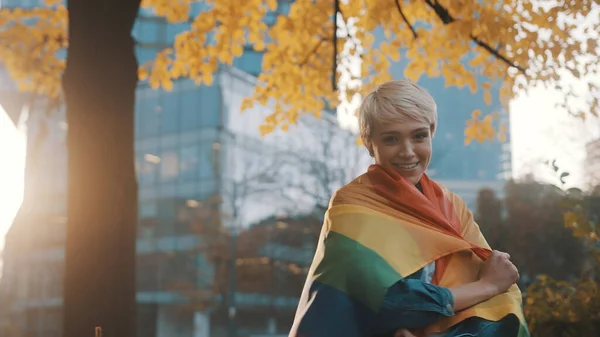 Beautigul jonge Kaukasische blonde kortharige vrouw bedekken zichzelf met regenboog vlag — Stockfoto