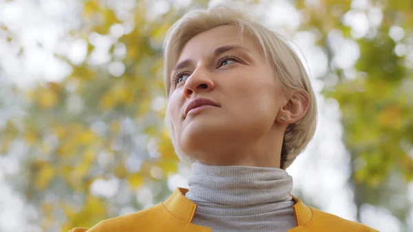 Porträt junge blonde modische Frau im gelben Mantel im Park — Stockfoto