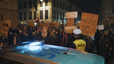 Varşova, Polonya 30.10.2020 - Kürtaj ve insan hakları protestosu, kadın grevi, polis arabasının yanından geçen göstericiler