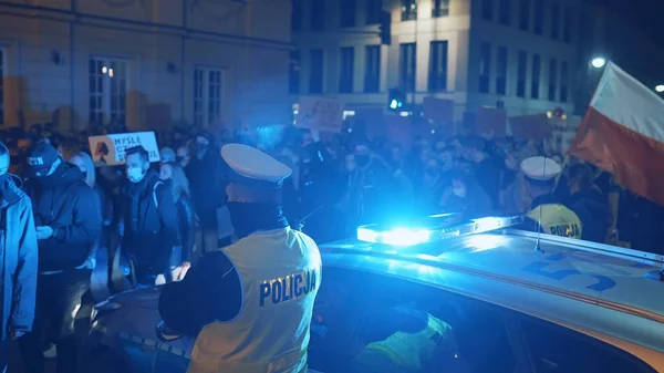 Warschau, Polen 30.10.2020 - Anti-abortus en mensenrechtenprotest, Vrouwenstaking, demonstranten in de buurt van politieauto verlicht door noodlicht — Stockfoto