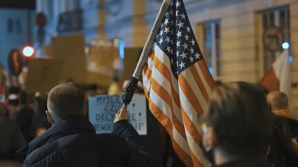 Warszawa, Polska 30.10.2020 - Protest przeciwko aborcji i prawom człowieka, strajk kobiet,. Mężczyzna trzyma flagę USA w tłumie — Zdjęcie stockowe