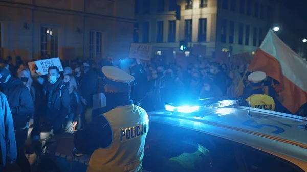 Warsaw, Poland 30.10.2020 - Anti abortion and human rights protest, Womens strike, demonstrants passing near police car illuminated by emergency light — Stock Photo, Image