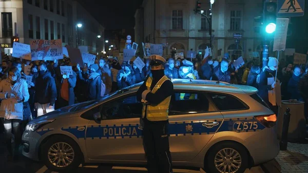Warschau, Polen 30.10.2020 - Anti-abortus en mensenrechtenprotest, Vrouwenstaking, demonstranten in de buurt van politieauto verlicht door noodlicht — Stockfoto
