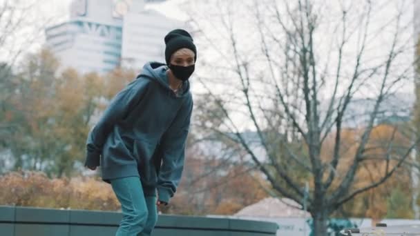 Mujer rubia joven con mascarilla patinaje en el skatepark en otoño — Vídeos de Stock