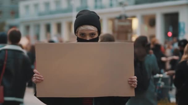 Protester och demonstrationer. upprorisk kvinna med ansiktsmask slående — Stockvideo