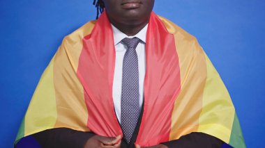 Tanınmayan Afro-Amerikalı şık takım elbiseli siyah adam gururlu gökkuşağı bayrağıyla kaplı