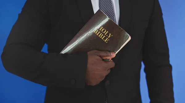 Close up, holy bible in the hands of black african american man in elegant suit — Stock Photo, Image