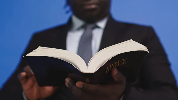 Close up, Bíblia sagrada nas mãos do homem negro afro-americano em terno elegante — Fotografia de Stock