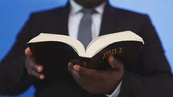 Close up, Bíblia sagrada nas mãos do homem negro afro-americano em terno elegante — Fotografia de Stock